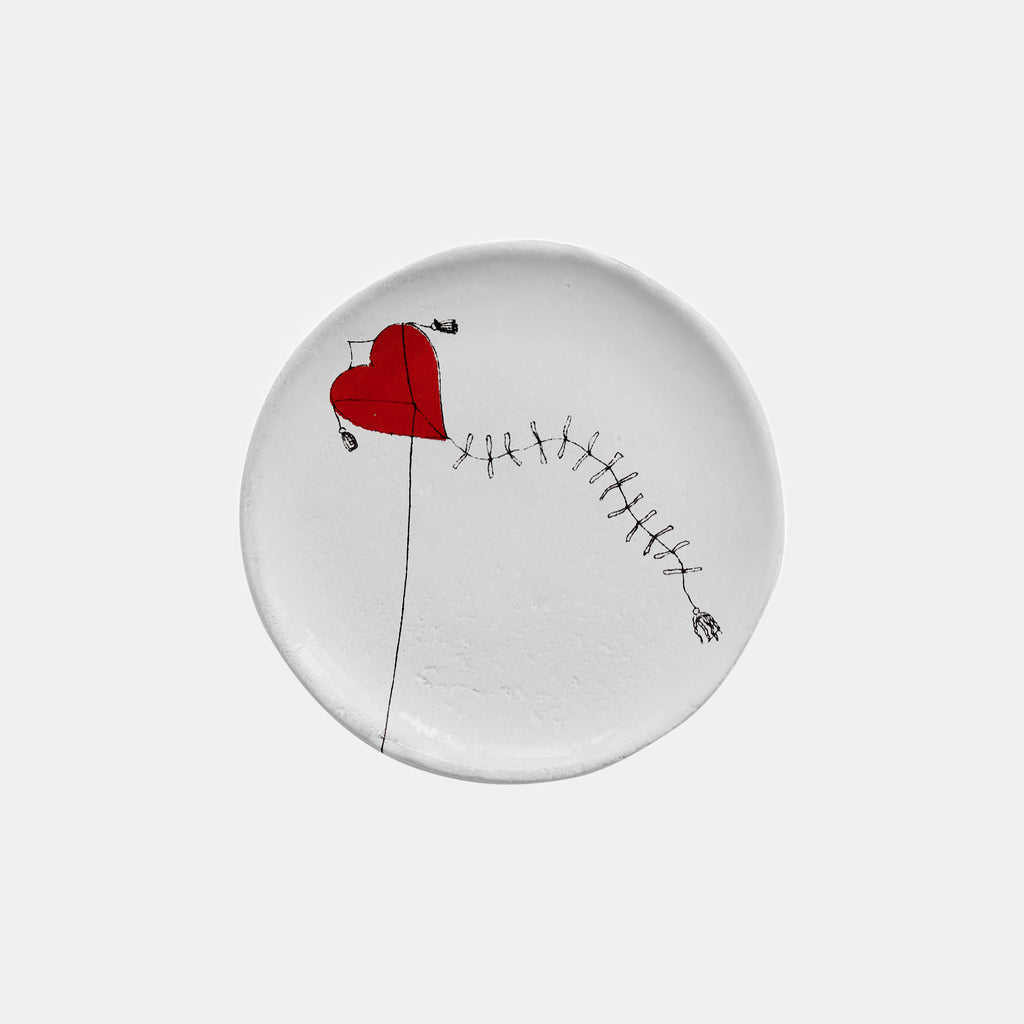 Small white ceramic plate dish with a heart and kite by Astier de Villatte in Amsterdam Netherlands