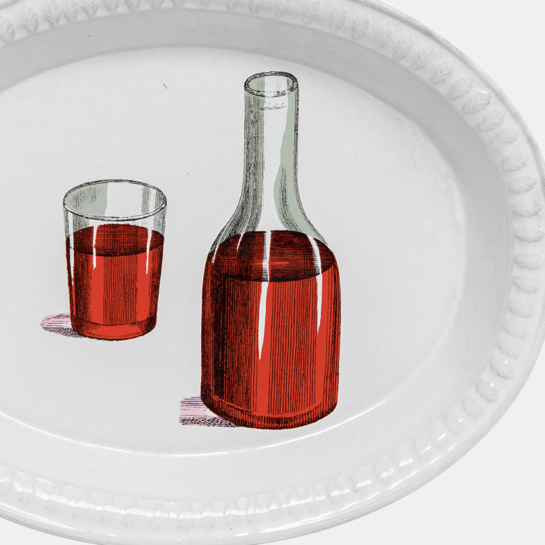 Witte keramische schotel met wijnfles en rode wijnglas van Astier de Villatte in Amsterdam Nederlands
